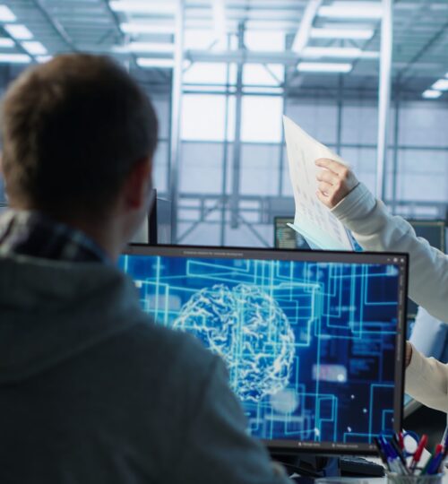 Manager conducting inspection in office, checking progress done by IT worker building AI diffusion model app. Team leader supervising engineer making software producing AI generated videos, camera A