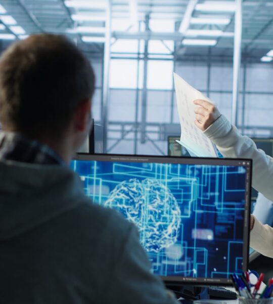 Manager conducting inspection in office, checking progress done by IT worker building AI diffusion model app. Team leader supervising engineer making software producing AI generated videos, camera A